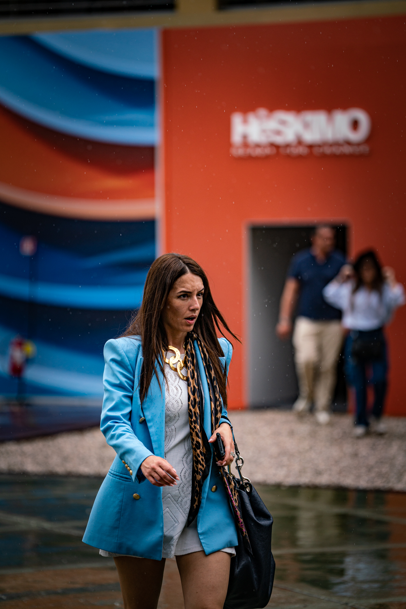 Pitti Uomo 104 - woman in blue suit walking in rain